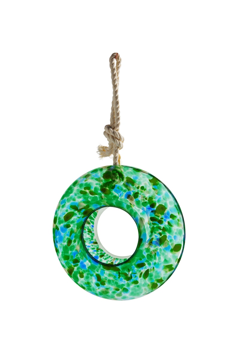 May include: A green and blue glass bird feeder shaped like a ring with a rope hanging from the top.