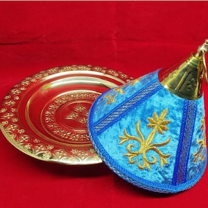 May include: A gold metal serving tray with an ornate design and a blue velvet cone-shaped lid with gold embroidery.