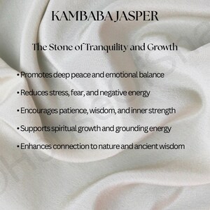 May include: Image featuring the text "KAMBABA JASPER" and "The Stone of Tranquility and Growth." The text is displayed on a white, textured fabric background. Bullet points list the stone's benefits, including promoting peace and reducing stress.