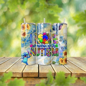 May include: Three stainless steel tumblers with lids and straws. Each tumbler features a design with sunflowers, the character Stitch, and the text "I love someone with autism". The tumblers are on a wooden surface.