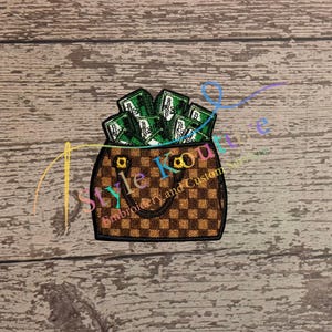 May include: A brown and tan checkered purse filled with green money. The purse has gold-colored hardware and is overflowing with cash. The image has the text "Style Kouture Embroidery and Custom Stitches".