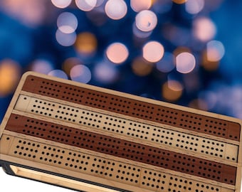 May include: A wooden cribbage board with alternating stripes of light and dark wood. The board has numerous small holes for peg placement and a dark border. The background is blurred with bokeh lights.