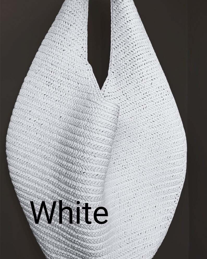 May include: A white hobo-style shoulder bag crafted from a woven, textured material. The bag features a single integrated strap and a slouchy, teardrop-shaped silhouette. The word White is printed in black sans-serif text on the lower left side.