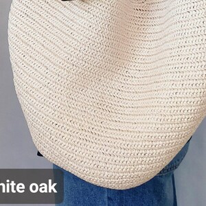 May include: A large, off-white woven straw tote bag with a textured, braided pattern. The bag features a rounded, slouchy silhouette and is positioned against a plain background. The text white oak is visible in the bottom left corner.
