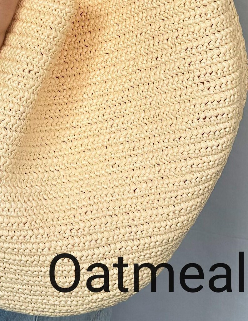 May include: A close-up view of a light beige, woven straw bag with a textured, braided surface. The word Oatmeal is printed in a bold, black, sans-serif font across the lower portion of the bag, clearly visible against the light-colored material.