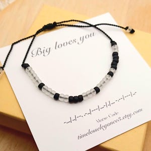 May include: Black and clear beaded bracelet with the message "Big loves you" in Morse code. The bracelet is on a white card with the Etsy shop's URL. The bracelet is adjustable.