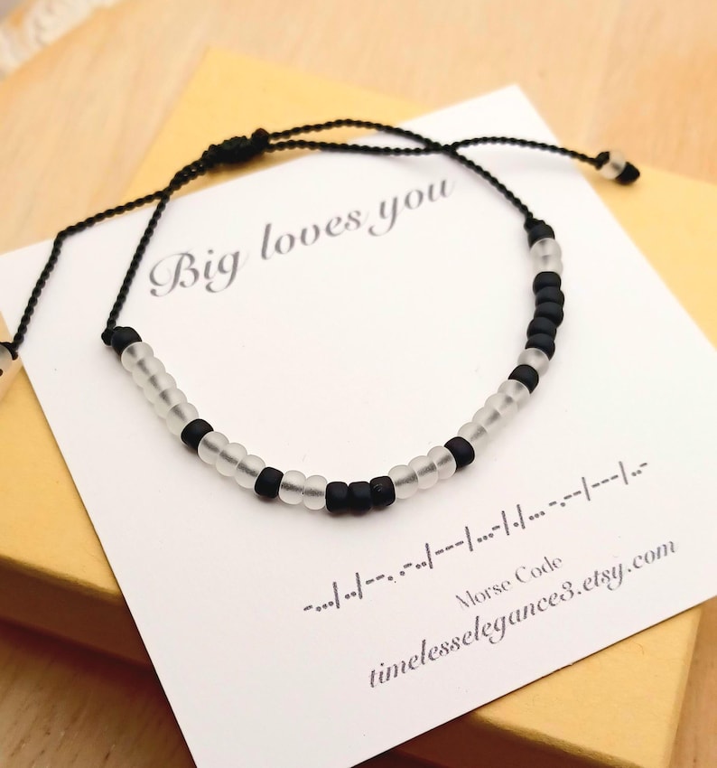 May include: Black and clear beaded bracelet with the message "Big loves you" in Morse code. The bracelet is on a white card with the Etsy shop's URL. The bracelet is adjustable.