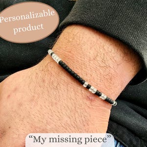 May include: A beaded bracelet with black and clear beads. The bracelet is on a wrist. Text on the image says "Personalizable product" and "My missing piece".