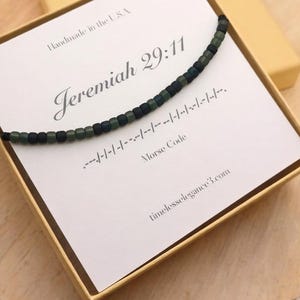 May include: A necklace with dark green and black beads, presented in a gold box. The card inside reads "Jeremiah 29:11" with Morse code and "timelesselegance3.com". Handmade in the USA.