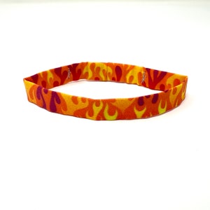 May include: A bright orange, yellow, and red headband with a flame-like pattern.