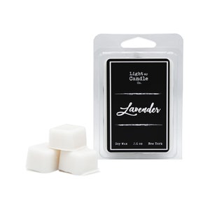 Puede incluir: Un paquete de pl&aacute;stico transparente que contiene una etiqueta negra con el texto "Light my Candle Co." y "Lavender" en escritura blanca. Tres cubos de cera blancos est&aacute;n frente al paquete. La etiqueta tambi&eacute;n dice "Soy Wax 73.7 g New York."