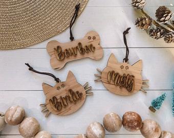Può includere: Tre ornamenti in legno con nomi personalizzati: "Bourbon", "Misty" e "Birdie". Gli ornamenti hanno la forma di un osso e di due gatti. L'ornamento a forma di osso ha impronte di zampe incise. Gli ornamenti a forma di gatto hanno impronte di zampe e un viso di gatto inciso.