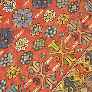 May include: A red, blue, yellow, and green patterned rug with a geometric design. The rug has a fringe border.