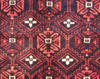 May include: A close-up of a red, black, and white patterned rug with a geometric design. The rug has a traditional, woven look.