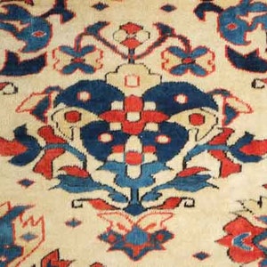 May include: Close-up of a beige rug with a detailed floral pattern. The design features large, stylized flowers in shades of blue and red, set against a cream-coloured background. The rug has a traditional, ornate aesthetic.