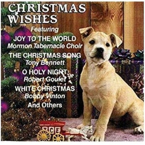 May include: A Christmas music compilation CD featuring a dog sitting on a festive background with a red and white toy wagon. The CD features songs like "Joy to the World", "The Christmas Song", "O Holy Night", and "White Christmas".