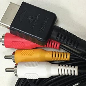 May include: A set of AV cables for connecting a video game console to a television. The cables include a black component video cable, a red and white RCA cable, and a yellow RCA cable. The component video cable has a connector labeled "SONY" and "PLAYSTATION 2".