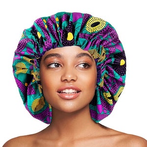 Puede incluir: Un gorro de dormir de satén con un diseño estampado en morado, verde y amarillo. El gorro está fruncido en la parte superior y tiene una banda elástica.