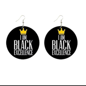 Könnte beinhalten: Ein Paar schwarze Holzohrringe mit einer goldenen Krone und dem Text "I am Black Excellence".
