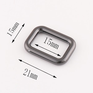 Puede incluir: Un anillo rectangular de metal negro con un di&aacute;metro interior de 15 mm y un di&aacute;metro exterior de 21 mm.