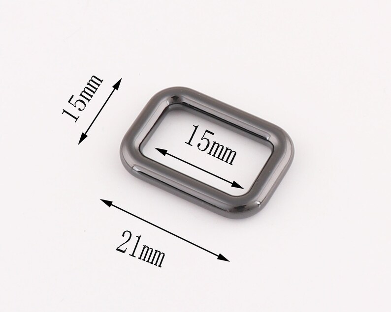 Puede incluir: Un anillo rectangular de metal negro con un di&aacute;metro interior de 15 mm y un di&aacute;metro exterior de 21 mm.