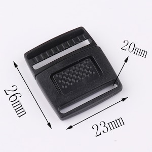 May include: Black plastic buckle with dimensions of 26mm by 23mm by 20mm.