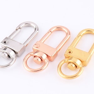 May include: Three metal swivel clasps in silver, rose gold, and gold finishes. Each clasp has a D-ring and a trigger snap.