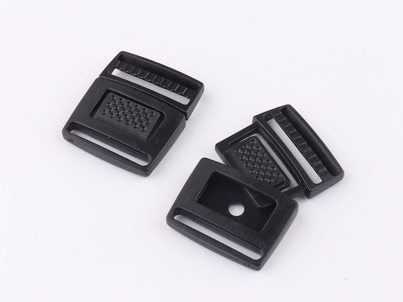 May include: Two black plastic side release buckles. The buckles are designed to be used with webbing or straps.