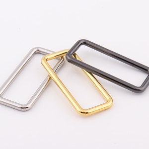 Peut inclure: Trois anneaux rectangulaires en m&eacute;tal argent&eacute;, dor&eacute; et noir.