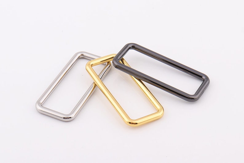 Peut inclure: Trois anneaux rectangulaires en m&eacute;tal argent&eacute;, dor&eacute; et noir.