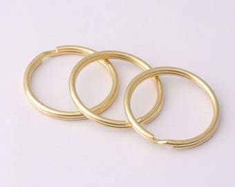 Op de afbeelding: Drie gouden metalen sleutelringen in verschillende maten.
