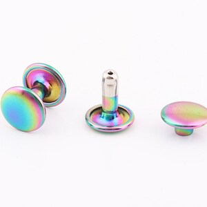 May include: Three iridescent rainbow colored metal rivets. The rivets are round and have a flat top. The rivets are used for attaching fabric or leather.