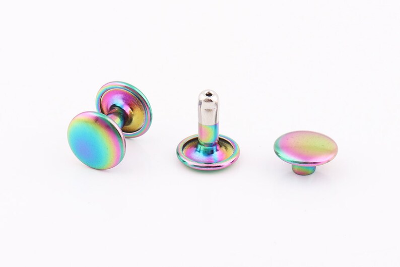 May include: Three iridescent rainbow colored metal rivets. The rivets are round and have a flat top. The rivets are used for attaching fabric or leather.