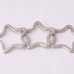 May include: Three silver star-shaped keychains linked together.