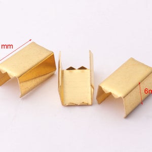 May include: Three gold metal slider buckles, each measuring 11 mm by 6 mm. These buckles are commonly used for straps, belts, and other DIY projects.