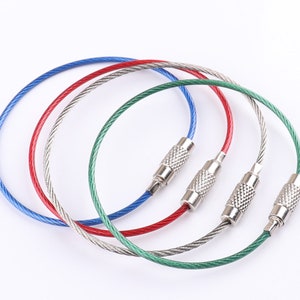 May include: Four keychains with metal rings and colored cable. The keychains are blue, red, green, and silver.