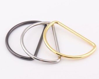 May include: Three metal D-rings in different finishes: gold, silver, and black.
