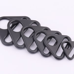 Könnte beinhalten: Ein Satz von fünf schwarzen D-Ringen aus Metall in verschiedenen Größen. Die Ringe sind dreieckig mit einer abgerundeten Öffnung.