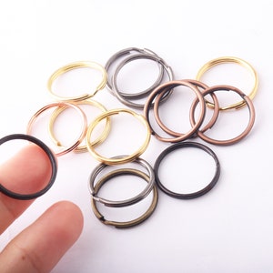 Puede incluir: Surtido de llaveros de metal en varios tamaños y colores, incluyendo oro, plata, bronce y cobre.