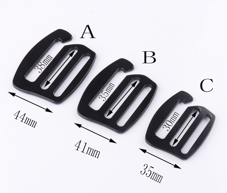 May include: Three black plastic slider buckles of different sizes. The largest buckle is 44 mm wide and 38 mm long. The middle buckle is 41 mm wide and 35 mm long. The smallest buckle is 35 mm wide and 30 mm long.
