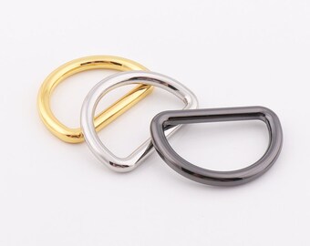 May include: Three metal D-rings in gold, silver, and black.