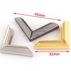 Puede incluir: Tres protectores de esquina de metal en plata, oro y negro. Los protectores miden 45 mm de largo y 32 mm de ancho.