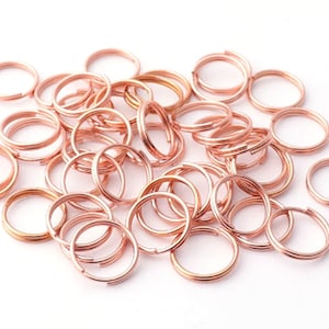Pode incluir: Um monte de argolas de salto de ouro rosa. As argolas são pequenas e delicadas, perfeitas para a fabricação de joias.