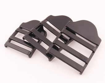 May include: Three black plastic buckle closures with four slots each. The buckles are designed to be used with straps or webbing.