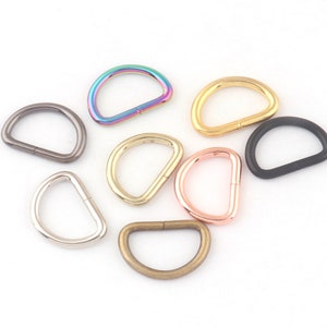 May include: Assortment of metal D-rings in various colors, including rainbow, gold, silver, and black. These rings are great for crafting, jewelry making, and other DIY projects.
