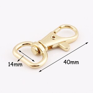 Könnte beinhalten: Vergoldeter Metall-Drehverschluss mit einem 14 mm D-Ring und einem 40 mm Haken.