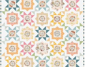 May include: A patchwork quilt featuring a grid of square blocks, each containing a central floral wreath with printed text. The blocks are framed by star-shaped borders in various pastel colors including pink, yellow, blue, and green, set against a white background.