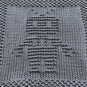 May include: A grey knitted dishcloth with a textured pattern. The dishcloth is made of cotton and is designed to be absorbent and durable.