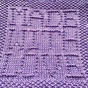 May include: A close-up of a purple knitted dishcloth with a textured pattern.
