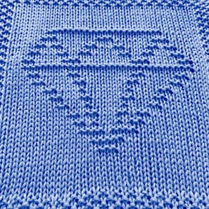 May include: A close-up of a blue knitted dishcloth with a diamond pattern.